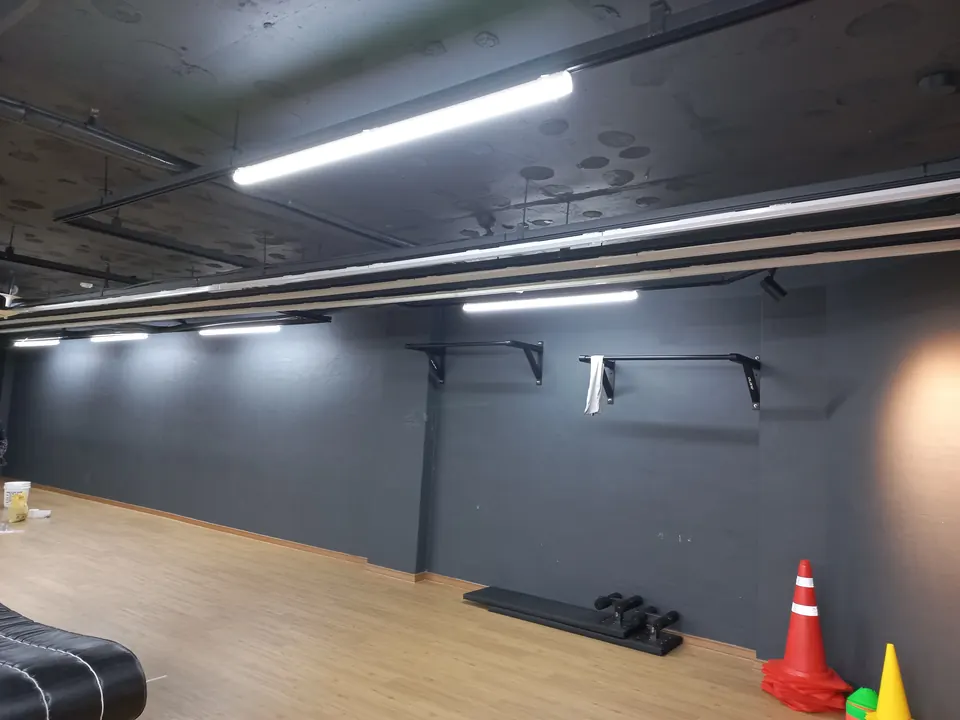 천장 레일을 따라 LED 라인 조명을 설치한 헬스장 내부