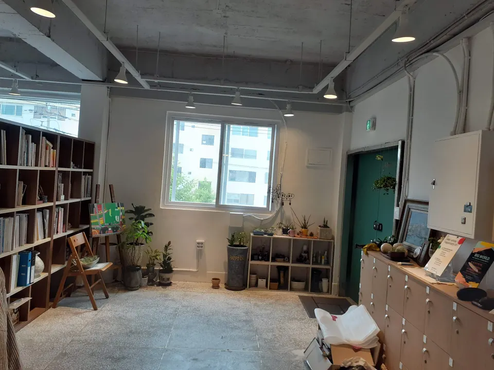 책장과 식물이 놓인 카페 안쪽 공간과 천장 조명