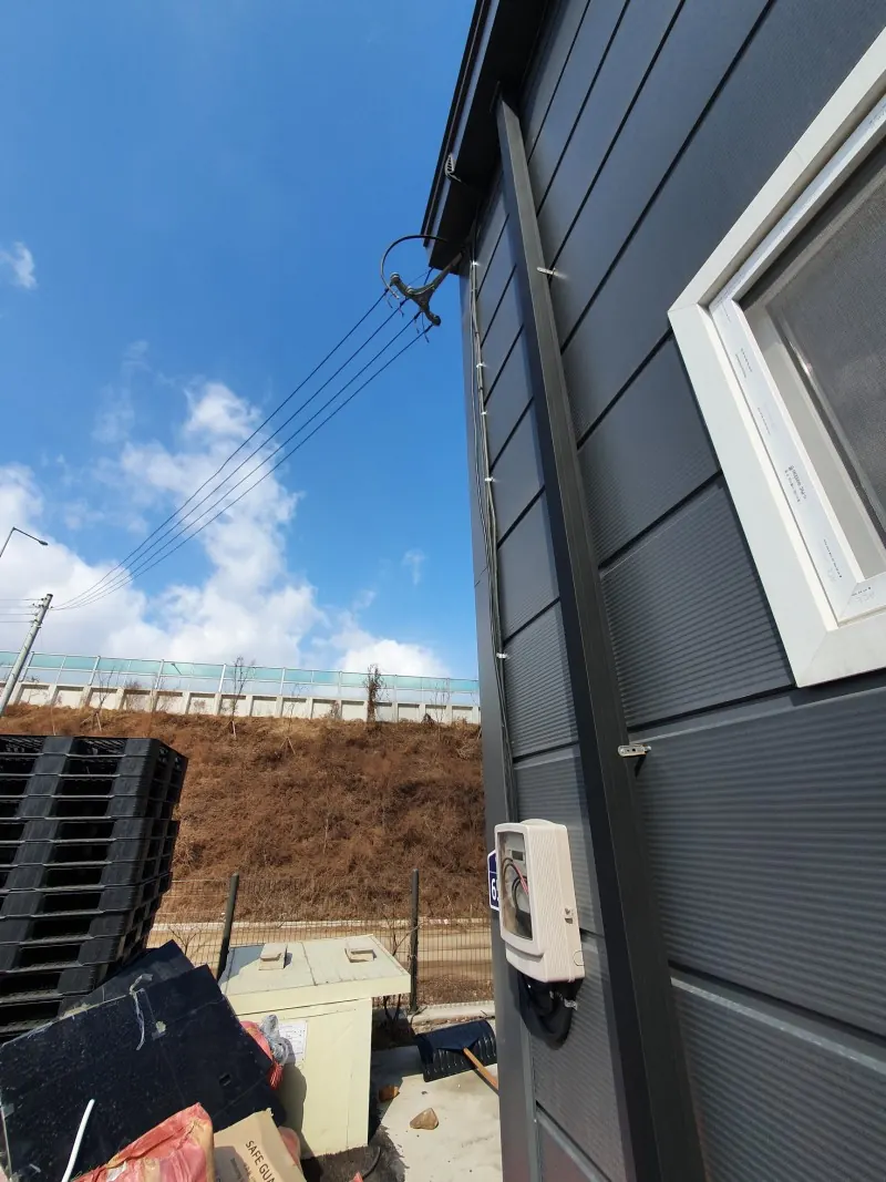 전신주 인입선이 연결된 공장 외벽과 계량기함 모습