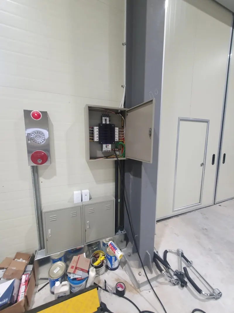 공장 벽에 분전함 외함을 달고 배선 작업을 진행하는 모습