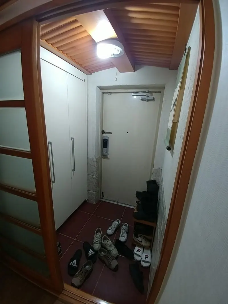 중문 설치 전 목재 천장과 센서등이 있는 아파트 현관