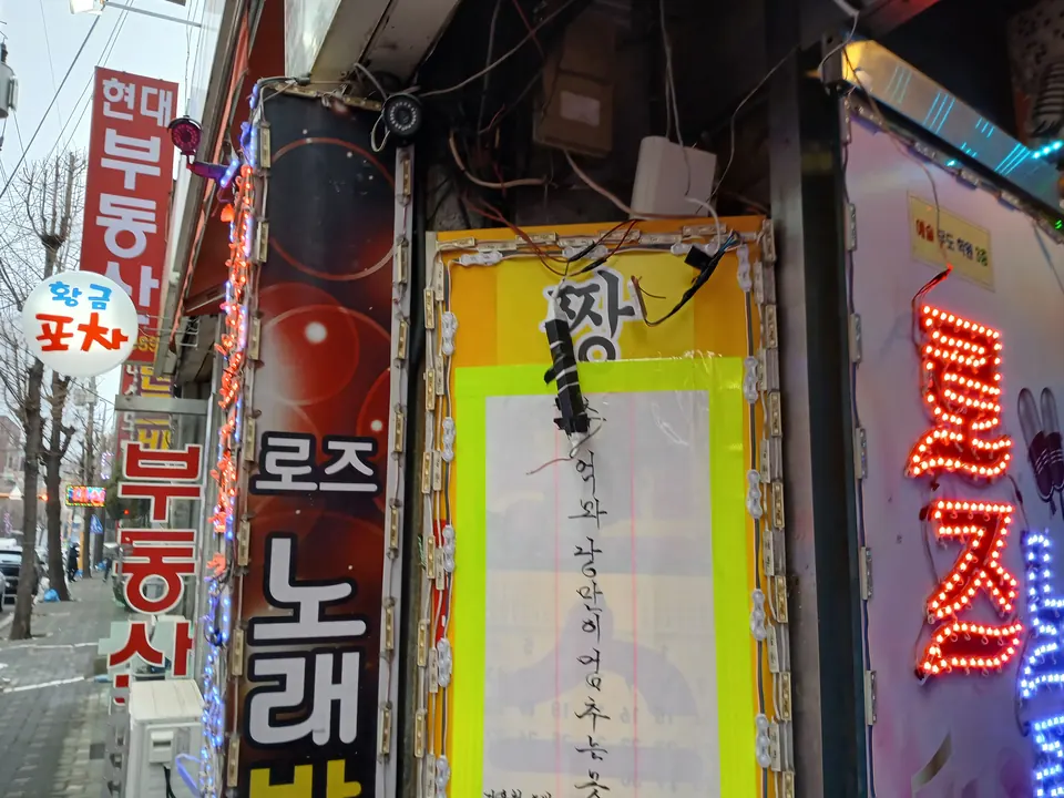 건물 외벽 간판 위쪽의 교체 전 LED 컨버터와 배선