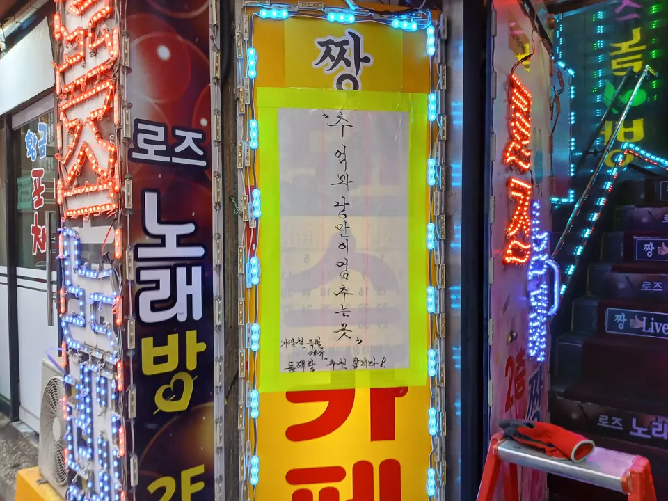 LED 모듈 조명이 다시 켜진 상가 입구 세로 간판 모습