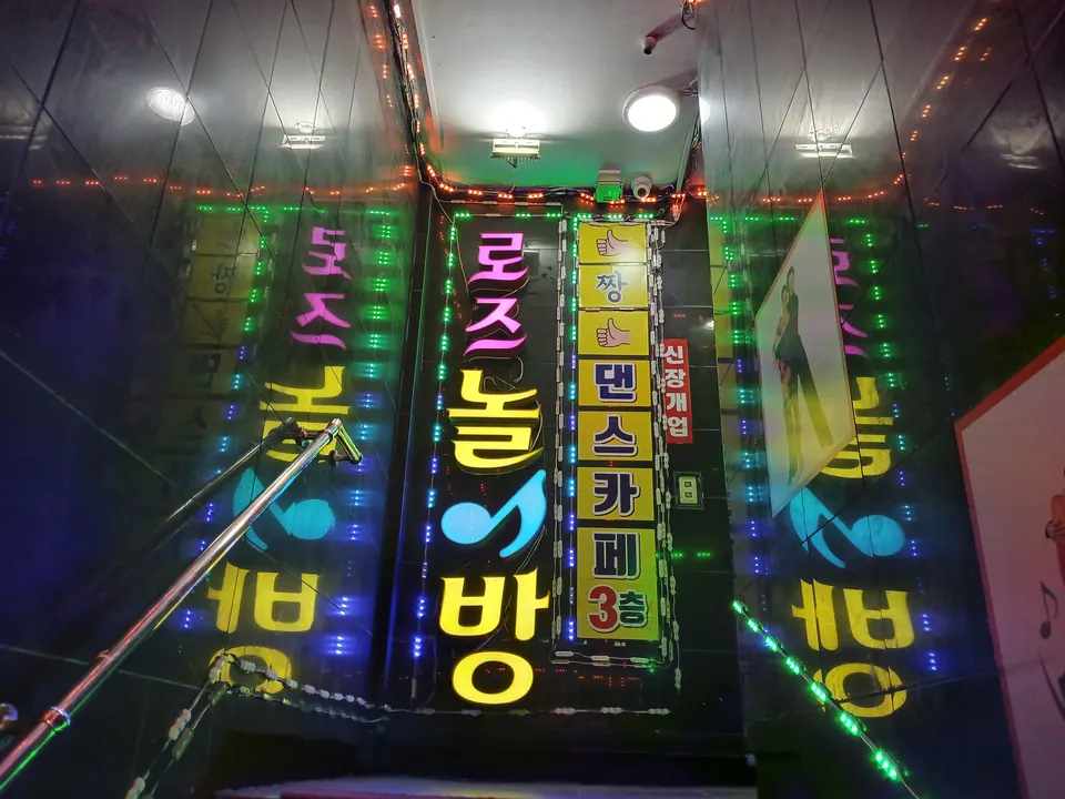 LED 조명이 켜진 라이브카페 계단 입구 벽면 간판
