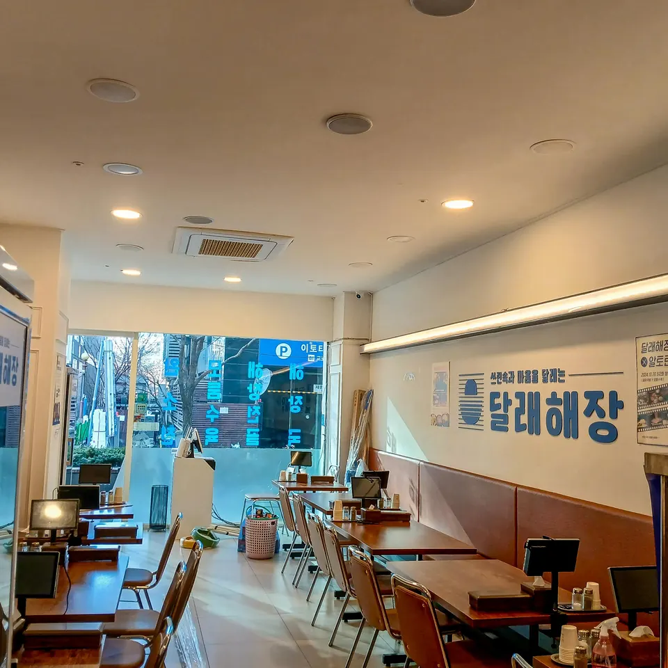 매립등과 라인 조명을 설치한 식당 창가 좌석 공간