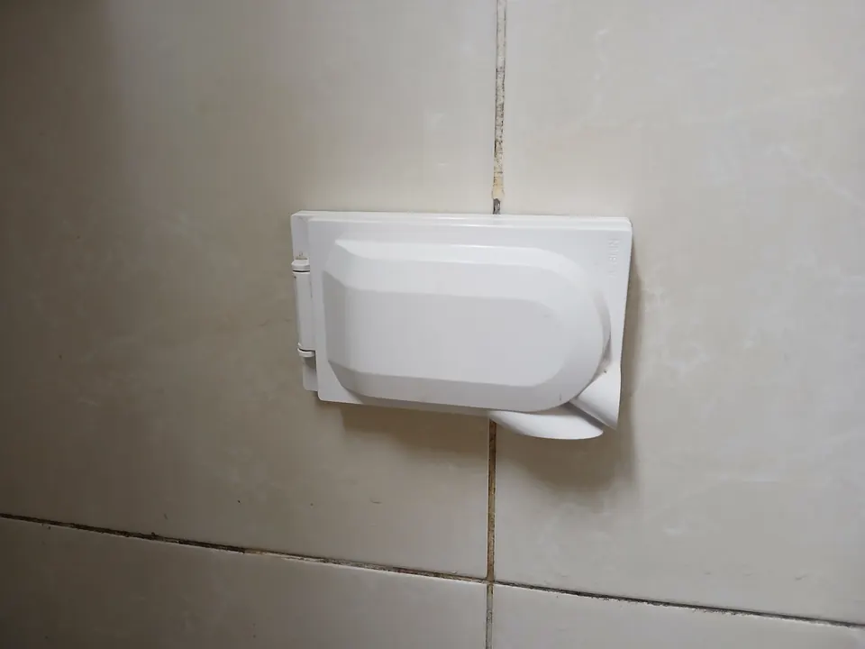 새 덮개형 방수 콘센트로 교체를 마친 욕실 타일 벽면