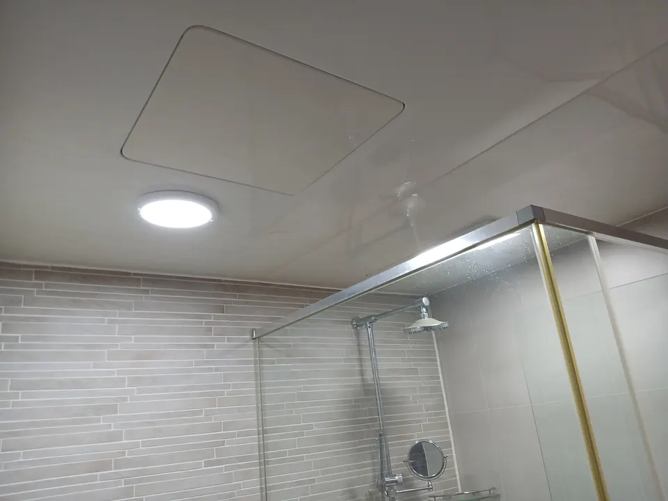 샤워부스가 있는 욕실 천장에 원형 LED등을 설치한 모습