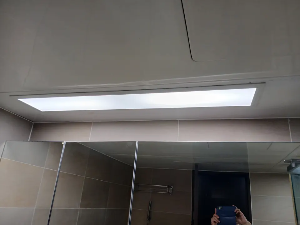 욕실 세면대 거울 위 천장에 설치한 일자형 LED 매입등 점등