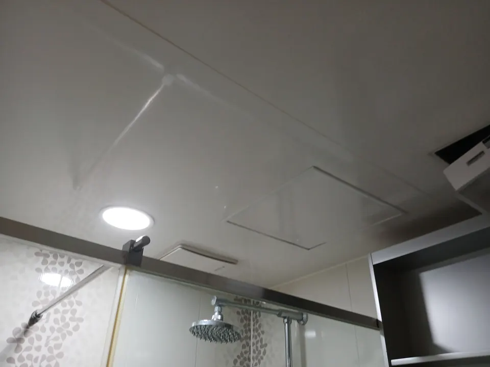 샤워부스 위 천장에 새로 설치한 원형 매입등이 켜진 모습