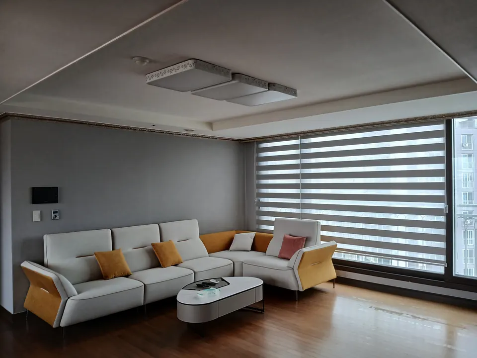소파 뒤편에서 본 거실 우물천장의 구형 사각 전등