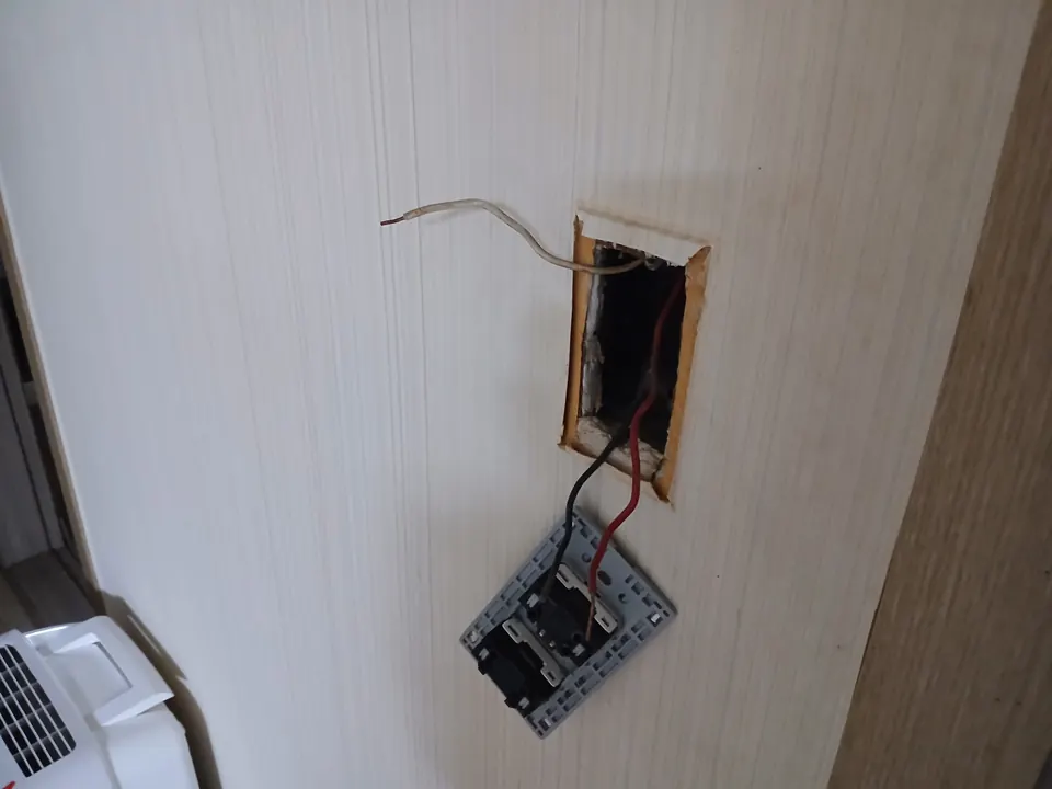 벽면 스위치를 떼어내 배선을 확인하는 교체 작업 중 모습